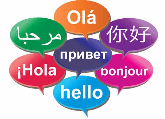 Seven colorful speech bubbles each display hello in different languages—including English, Spanish, French, Russian, Arabic, Chinese, and Portuguese—on a white background, bringing an international flair reminiscent of Curacao's vibrant culture.