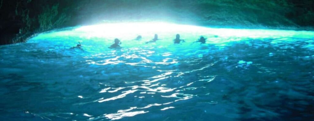 Experience the magic of the Curacao Beach and Blue Room speedboat tour adventure, where swimmers float in luminous blue waters inside the cave—illuminated by natural light from a secret entrance, making for an unforgettable highlight.